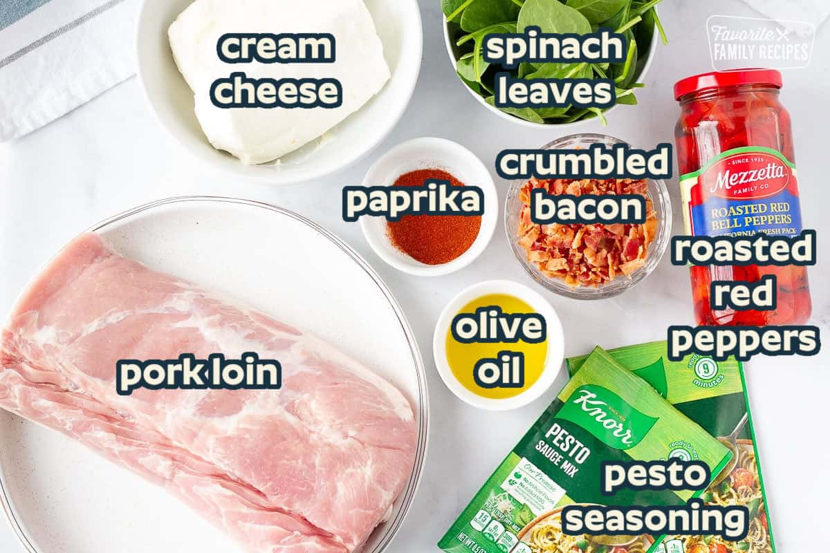 Ingredients to make Stuffed Pork Loin including, Pork Tenderloin, cream cheese, spinach, bacon, paprika, olive oil, pesto sauce mix and roasted red bell peppers.