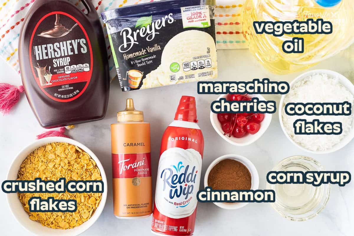 Ingredients to make Fried Ice Cream including ice cream, oil, chocolate syrup, caramel sauce, corn flakes, cinnamon, corn syrup, coconut, whipped cream and cherries.