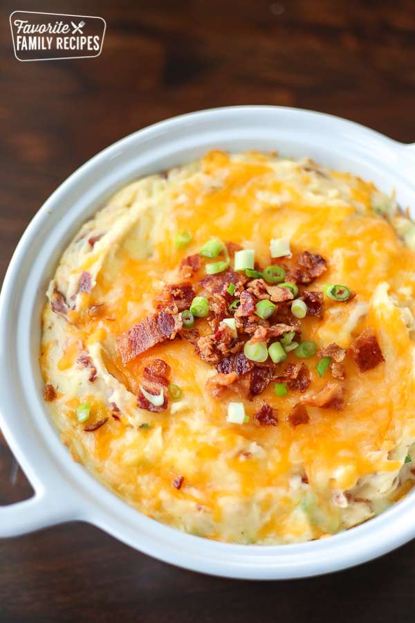 A white baking dish filled with loaded potatoes. 