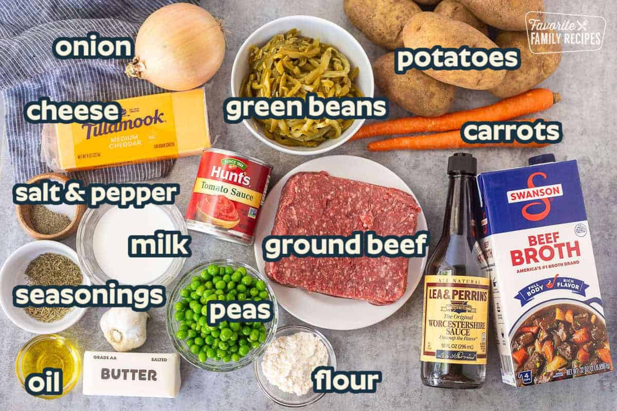 Ingredients to make shepherds pie including beef broth, Worcestershire sauce, carrots, potatoes, ground beef, flour, green peas, tomato sauce, butter, garlic, rosemary, thyme, salt, pepper, milk, oil, cheese, onion and French style green beans.