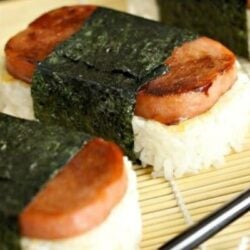 Spam Musubi, rice and spam wrapped in seaweed, on a bamboo sheet