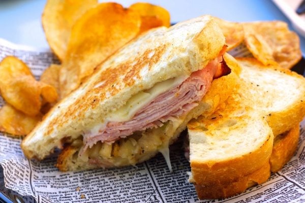 Grilled ham sandwich with kettle chips.