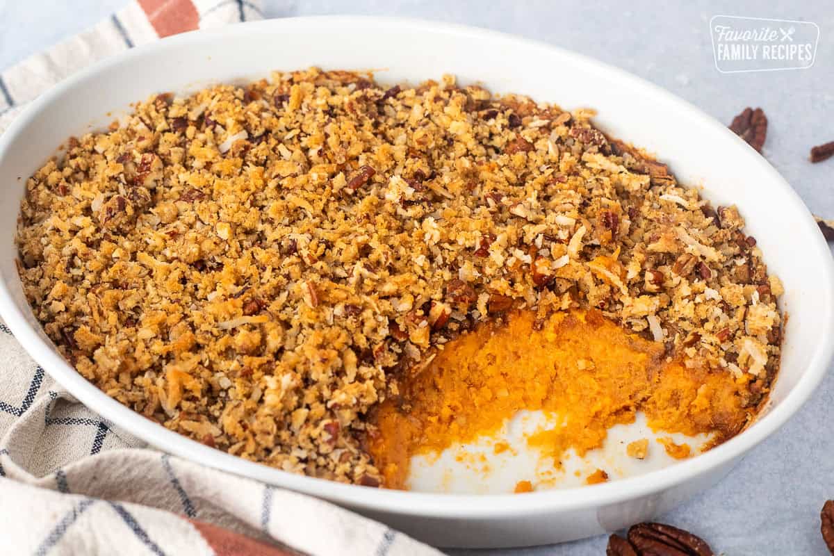 Sweet Potato Casserole with Pecan Topping in a casserole dish with scoop out of it.