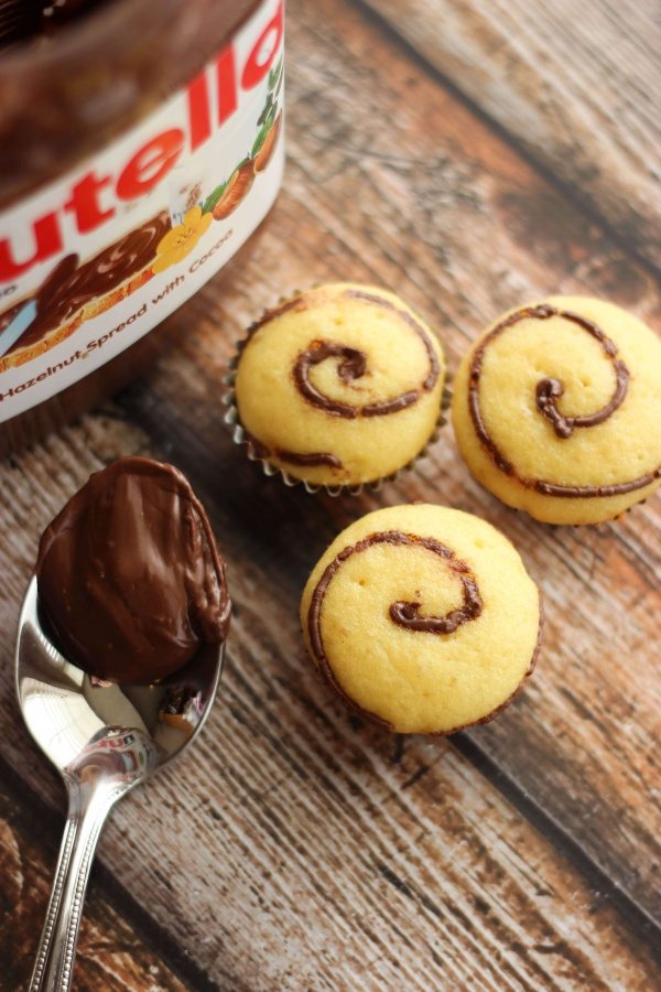 Nutella Swirl Cupcakes with a spoon filled with Nutella. 