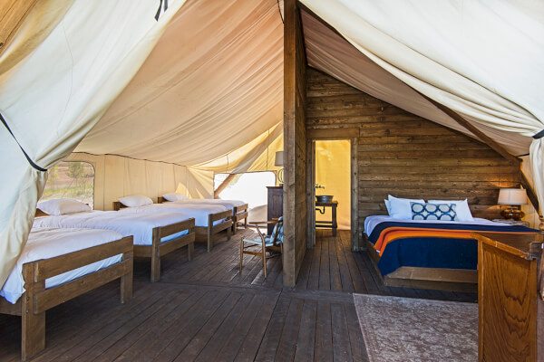 You can use it as a smoker. You can use it as a grill. You can use it for both. A tent with four white beds and a king size bed on the right side.
