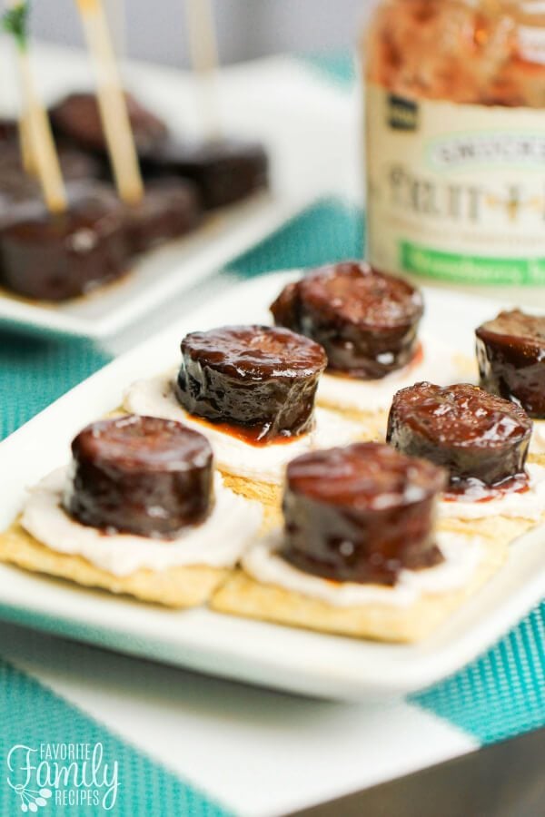 This Easy Kielbasa Appetizer is sweet, savory and packs a spicy punch! Perfect little bites for game day, holiday buffets, or any party! Kielbasa Appetizer on a white plate.