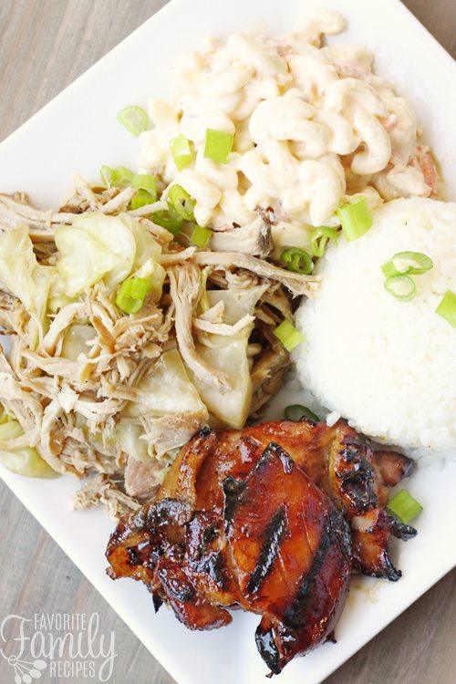 Grilled Hawaiian teriyaki chicken with white rice, macaroni salad, and pork on the side all on a white plate.