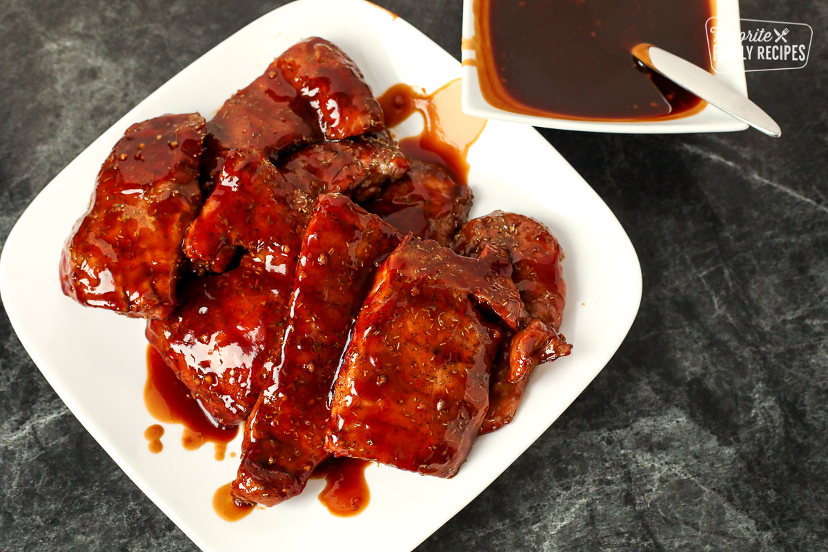 Plate full of pork tenderloin and a side of bbq sauce