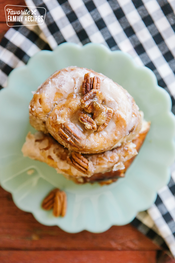 A slice of a Dutch Oven Cinnamon Roll on a plate with a gingham napkin to the side