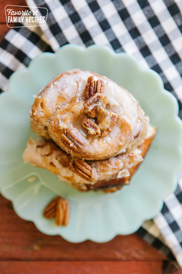 A slice of a Dutch Oven Cinnamon Roll on a plate with a gingham napkin to the side.