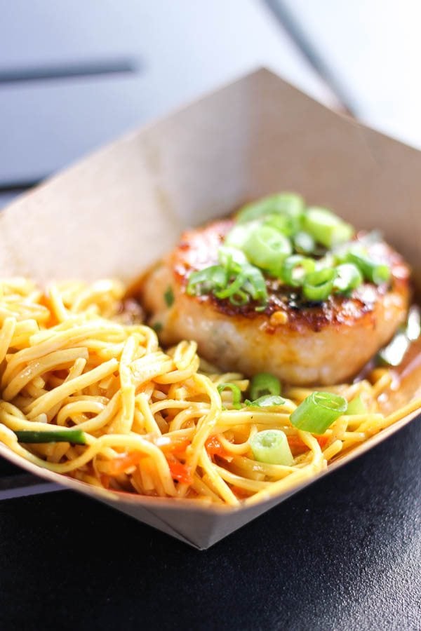 Seared shrimp and scallop cake with noodles in a brown bowl. 