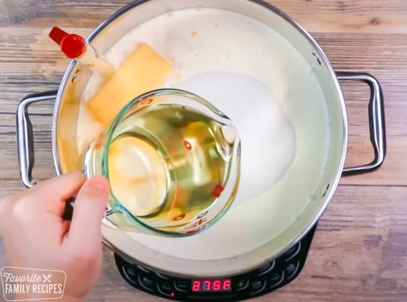 Corn syrup being poured into a pot for caramels