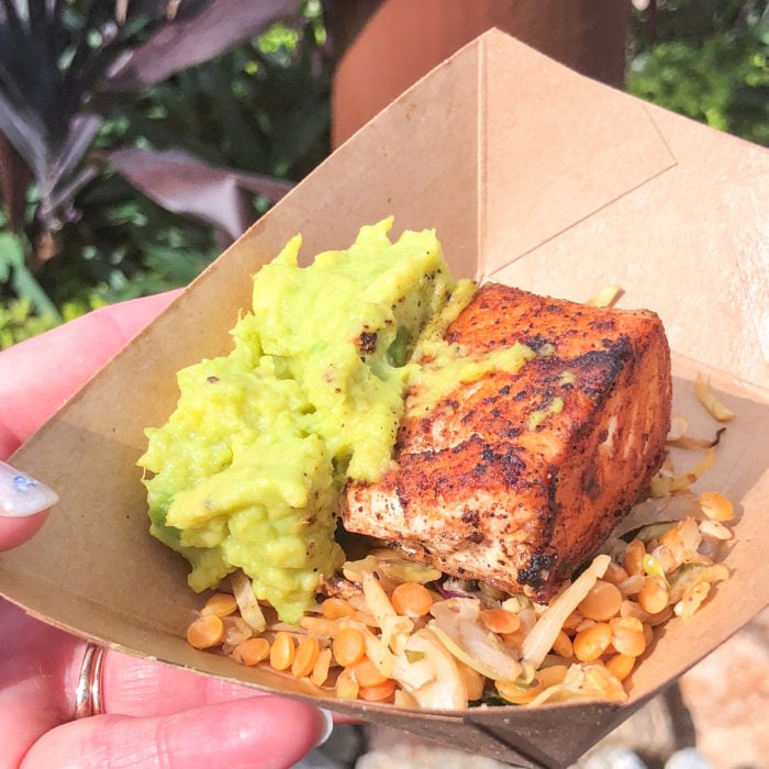 Spice crusted verlasso salmon with lentil salad and avocado in a brown bowl. 