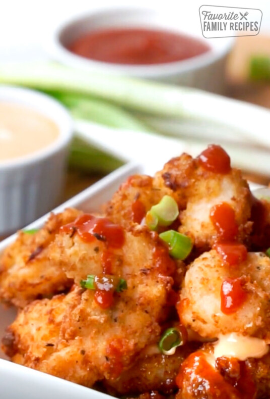 Bang Bang Shrimp in a bowl with two sides of sauce