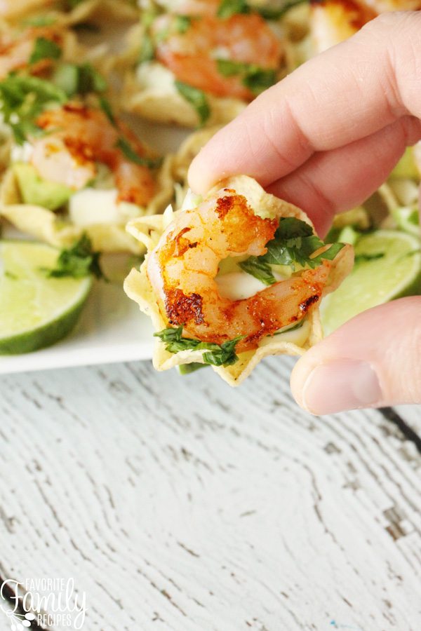 A shrimp taco being held by a hand. 