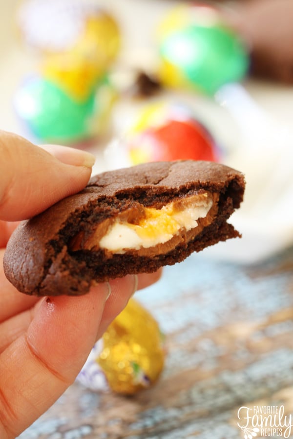 Cadbury Creme Egg Stuffed Easter Cookies so rich and decadent! Fudgy cookies with your favorite Easter candy baked right in the center. YUM! Chocolate Easter Cookies with a bite out of it.