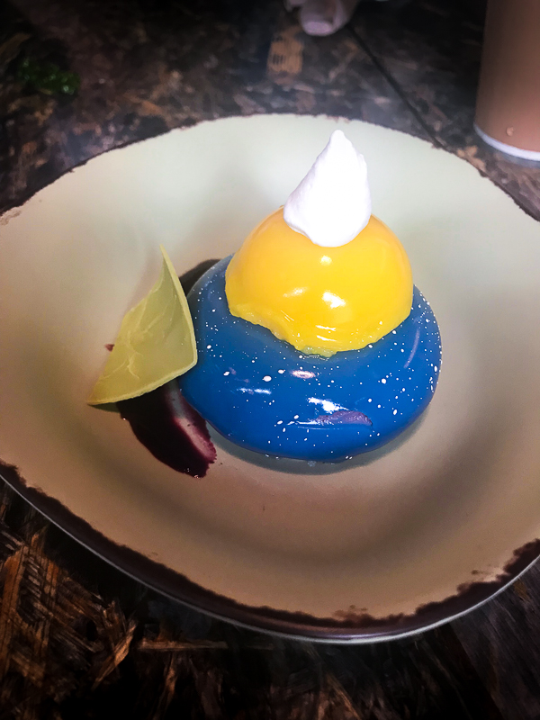 A white plate with a blueberry cream cheese mouse dessert. 