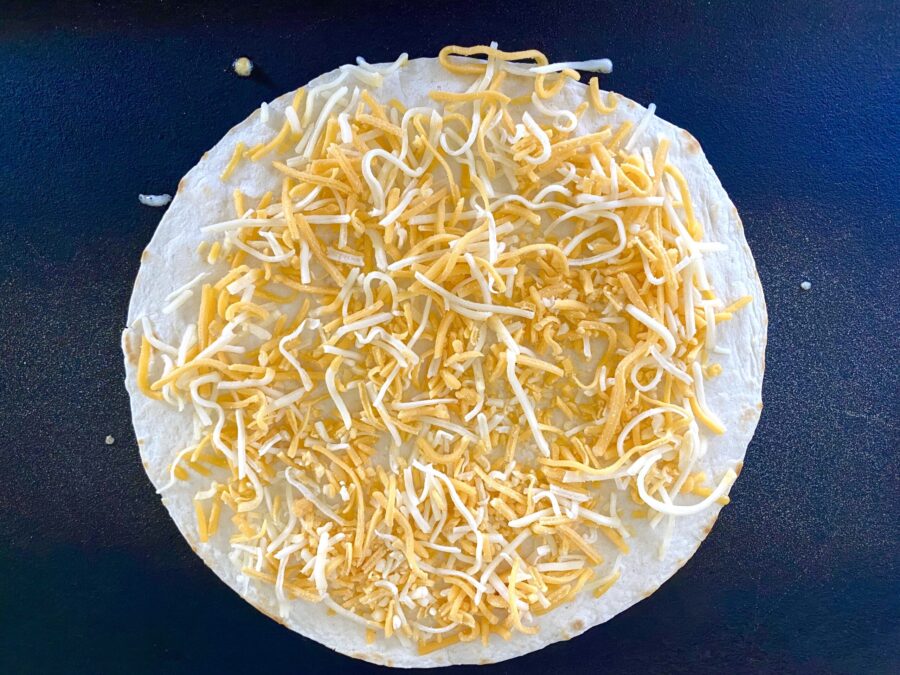 shredded cheese on a tortilla