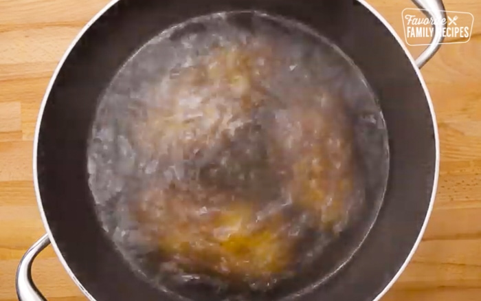Potatoes parboiling in a pot for has browns