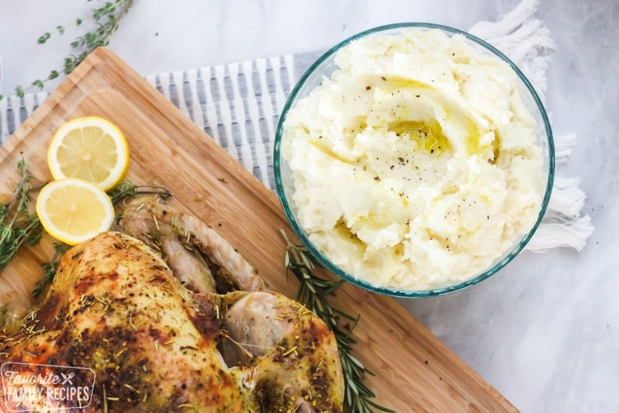 Bowl of mashed potatoes next to a roasted turkey.