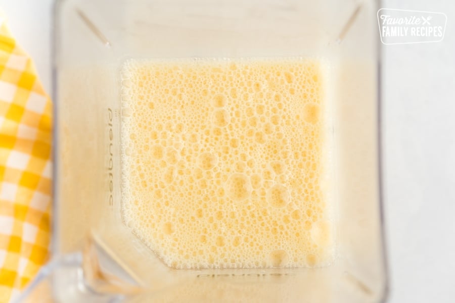 Orange juice concentrate, milk, water, vanilla, and sugar mixed in a blender