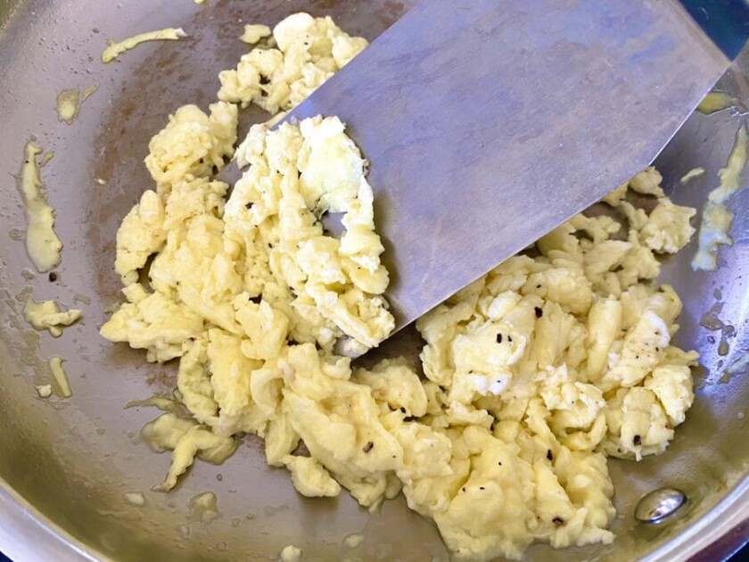 eggs being scrambled in a pan