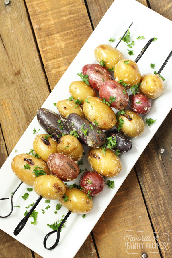 Grilled parmesan potatoes on a white platter. 