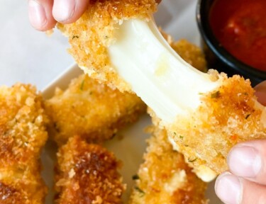 Mozzarella stick being pulled to show cheese
