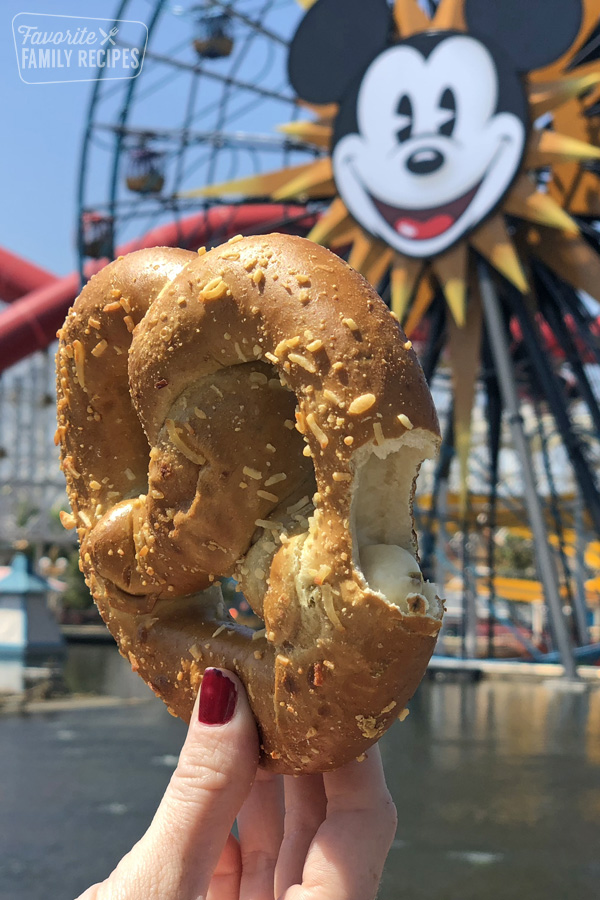 Jalapeño Cheese Filled Pretzel being held in front of the Mickey Mouse Ferris Wheel at Disney's California Adventure