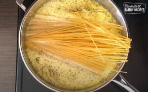 Aggiungere i noodles a una pentola cremosa di noodles all'aglio