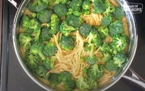 Aggiungere i broccoli a una pentola di spaghetti cremosi all'aglio