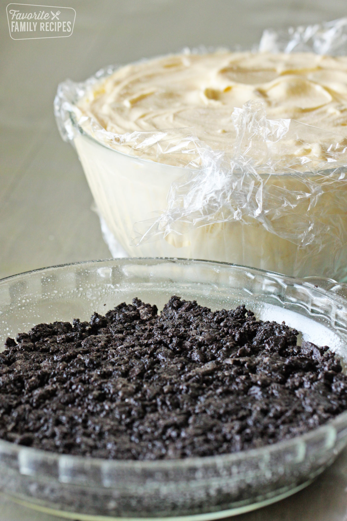 Oreo pie crust with a mixing bowl filled with macadamia nut ice cream