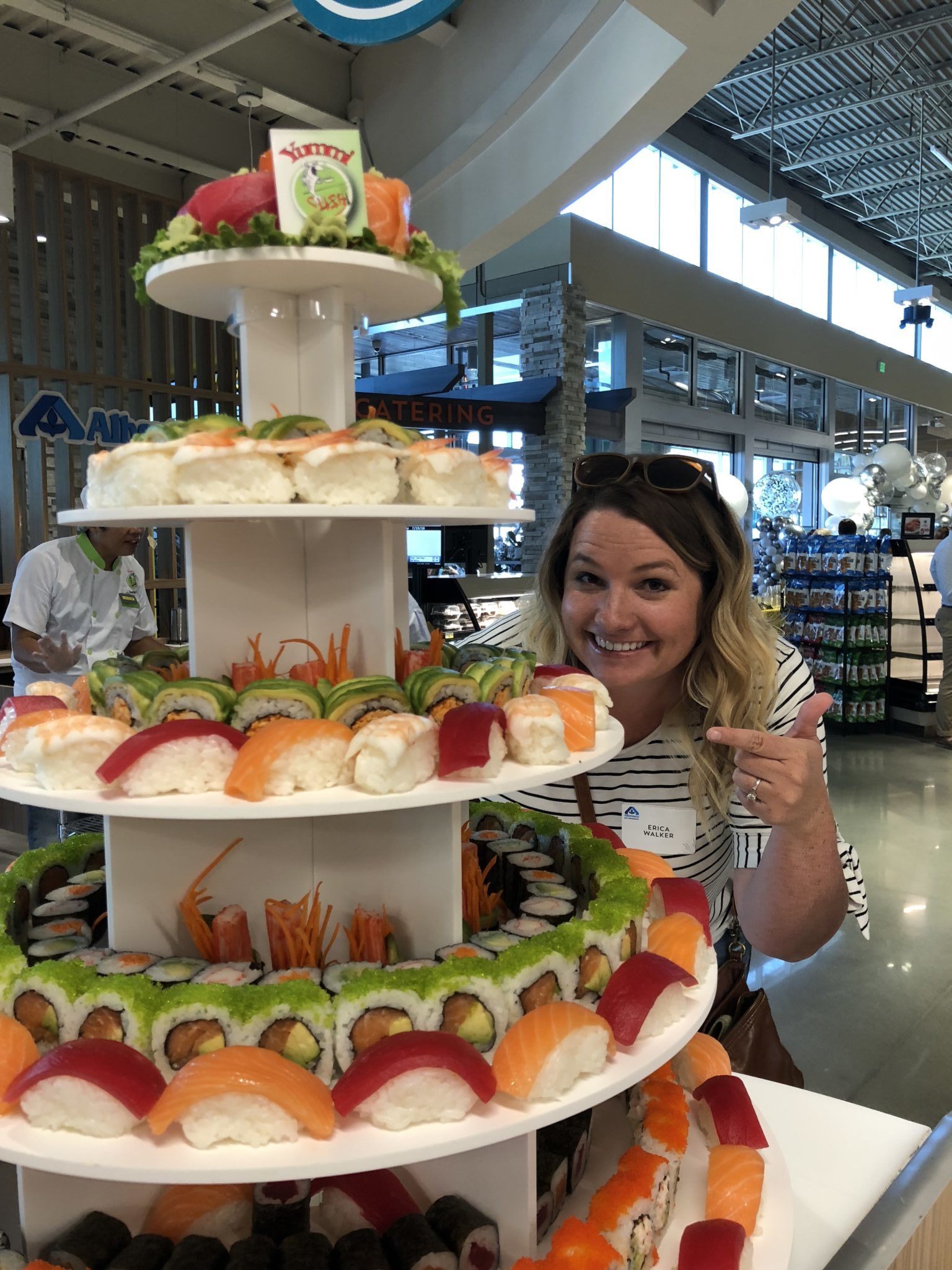 Erica pointing to the Sushi Tower at the Albertsons grand opening in Boise