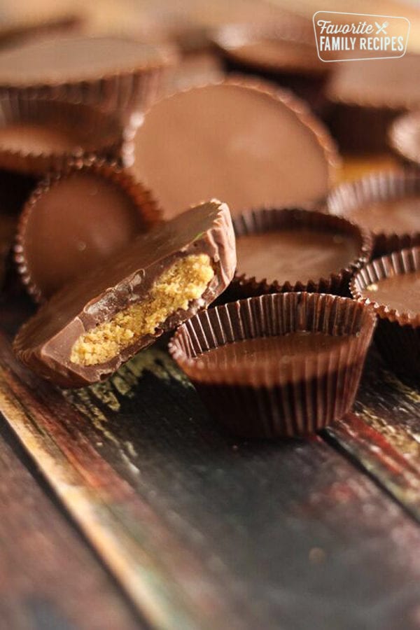 homemade peanut butter cups on a wood board with a bite taken out of one peanut butter cup