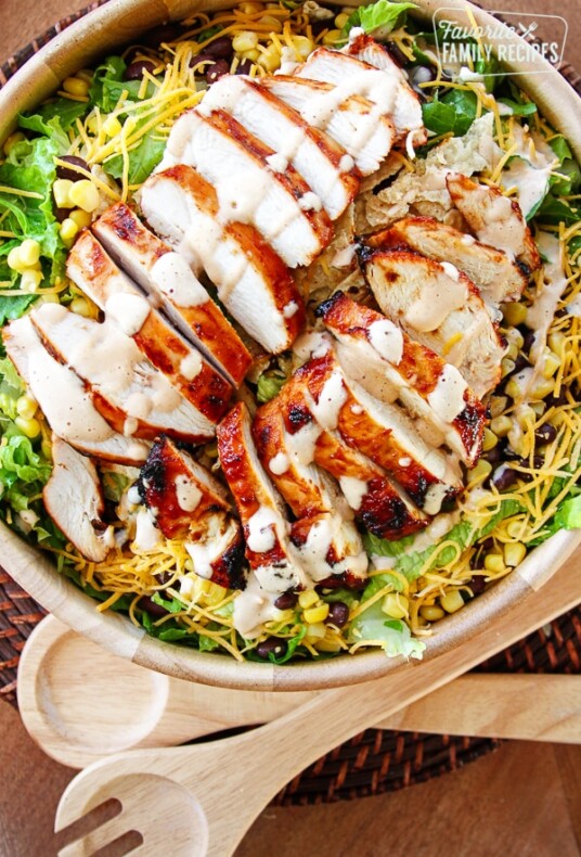 BBQ Chicken Salad with Creamy BBQ Dressing in a wooden bowl with 2 wooden spoons off to the side.