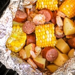Cajun Shrimp Foil Packets with corn and potatoes on a grill