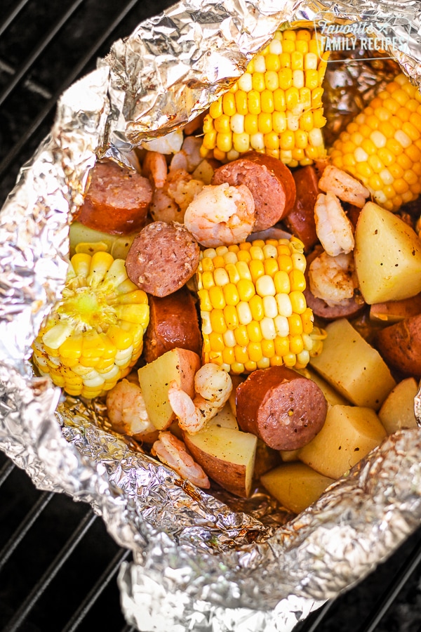 Cajun Shrimp Foil Packets with corn and potatoes on a grill