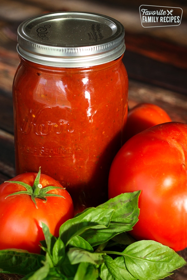 Jar of spaghetti sauce with fresh tomatoes and basil
