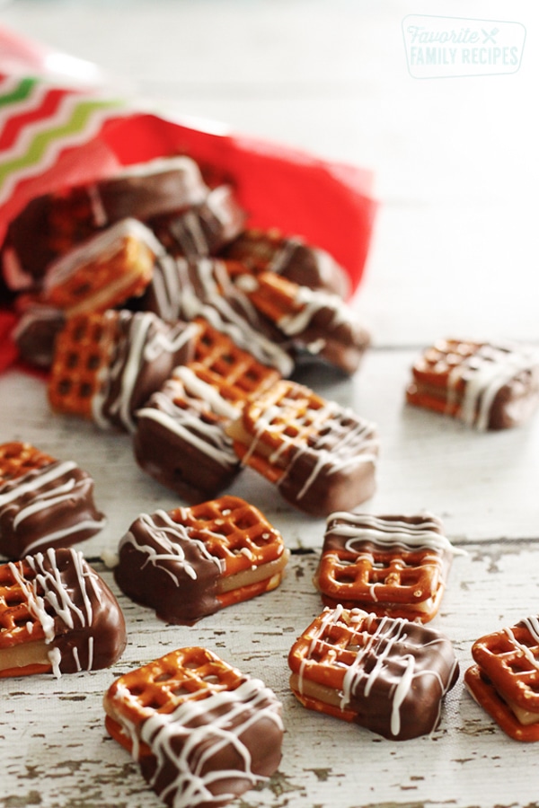 Several Dipped Caramel Pretzel Bites scattered on a white surface.