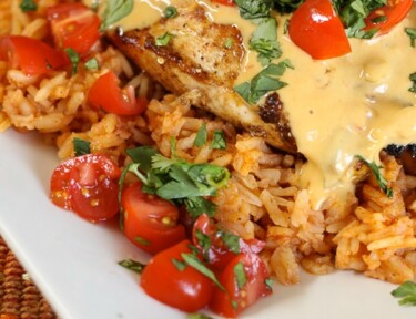 Mexican chicken served on a bed of rice topped with chopped tomatoes and cilantro