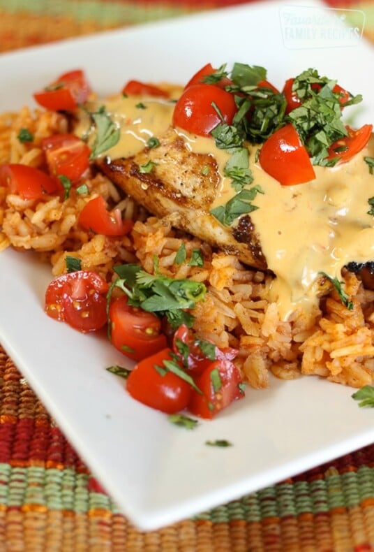 Mexican chicken served on a bed of rice topped with chopped tomatoes and cilantro