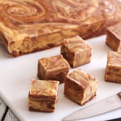 Chocolate Peanut Butter Fudge Swirl slab with cut up pieces on a cutting board