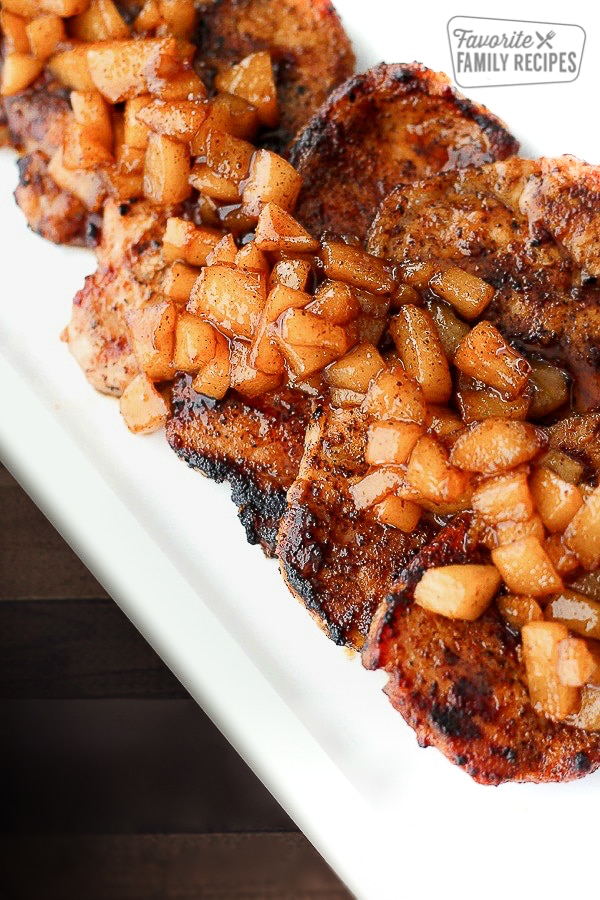 Cinnamon Pork Chops topped with Spiced Pears all on a white tray.