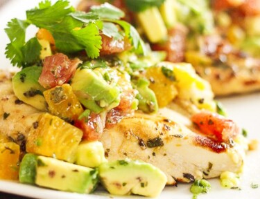 Chicken breast topped with avocado and citrus fruits on a plate Breast Recipe