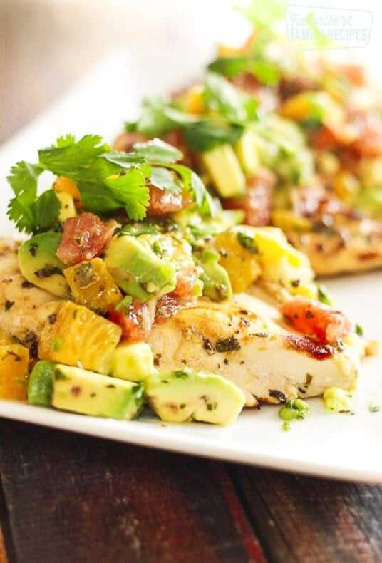 Chicken breast topped with avocado and citrus fruits on a plate Breast Recipe