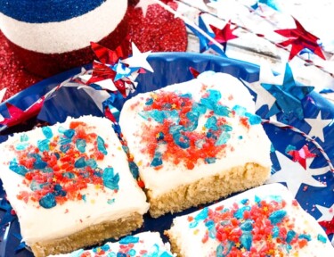 4 Firecracker Sugar Cookie Bars on a plate surrounded by fourth of july decorations.