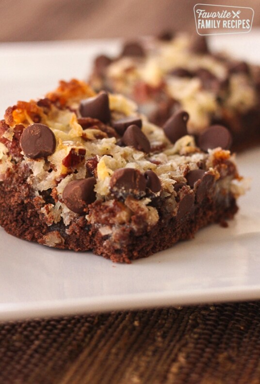 A German Chocolate Cookie Bar with another one in the background on a plate.