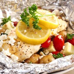 Greek Lemon Chicken Foil Packets with Vegetables and lemon slices topped with a garnish