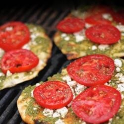 3 Grilled Pesto Pizzas topped with tomatoes on a grill