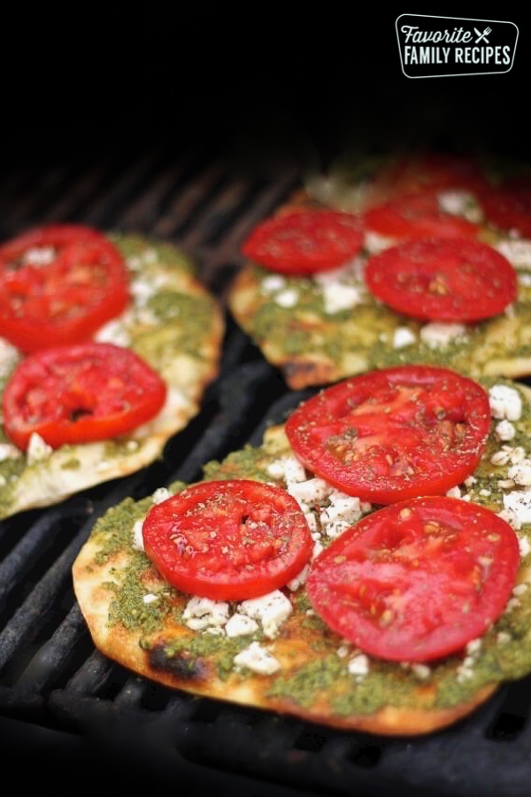 3 Grilled Pesto Pizzas topped with tomatoes on a grill